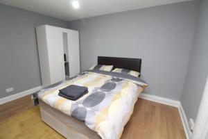 a bedroom with a bed with a black and white comforter at Modern 2 Bed Close to City in London