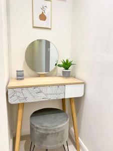 a vanity with a mirror and a stool in a room at The Waterbaby in Calstock
