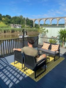 a man sitting in a chair on a deck at The Waterbaby in Calstock