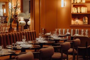 - un restaurant avec des tables et des chaises dans une salle dans l'établissement Sofitel Paris Baltimore Tour Eiffel, à Paris