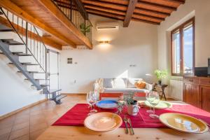 Un comedor con una mesa con platos y copas de vino. en Brunelleschi View Suite, en Florencia