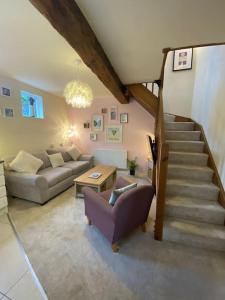 a living room with a couch and a staircase at The Old Stable in Shifnal