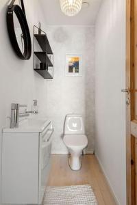 a white bathroom with a toilet and a sink at Cozy home. Fantastic view and parking in Tromsø