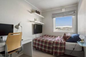 a bedroom with a bed and a desk and a window at Cozy home. Fantastic view and parking in Tromsø
