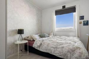 een slaapkamer met een bed en een raam bij Cozy home. Fantastic view and parking in Tromsø