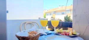 a table with two glasses of wine and a basket of food at IH Apartments & Studios in Espinho