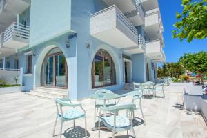 a patio with tables and chairs on a building at Kos Bay Hotel in Kos Town