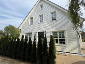 a white house with trees in front of it at stilvolle Ferienwohnung Sweet Magnolia in Kühlungsborn