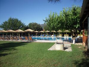 a swimming pool with chairs and umbrellas at Stalaktites Studios in Sami