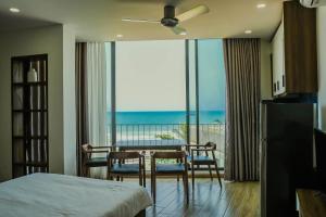 a bedroom with a table and chairs and a balcony at Anstay Beach Da Nang in Danang +75 photos