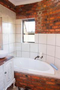 uma casa de banho com uma banheira e uma janela em Matusadona Guest Lodge em Hillcrest