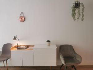 un escritorio blanco con 2 sillas y una lámpara en Yerseke Maarten & Hanh en Yerseke