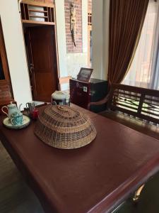 una mesa de madera con un sombrero encima en Rumah Jati Bantul, en Jarakan