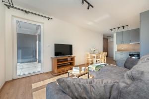 un soggiorno con divano e TV di Wrocław 1-Bedroom Apartment with Parking & Balcony by Renters a Breslavia