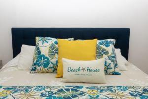 Bett mit blauem Kopfteil und Kissen in der Unterkunft New! Cozy 1 Bedroom Condo- Gold Coast, Noord ARUBA in Palm-Eagle Beach