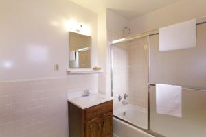 een witte badkamer met een wastafel en een douche bij Town House Motel in Winnemucca