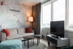 sala de estar con sofá y TV en Scandic Byporten, en Oslo