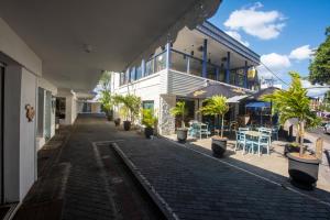 a street with a building with plants and tables at Dodo Square in Grand-Baie