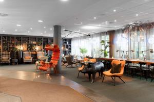 a lobby with chairs and a bar in a building at Scandic Byporten in Oslo