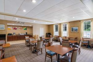 a dining room with tables and chairs and a kitchen at Quality Inn Mystic-Groton in Mystic