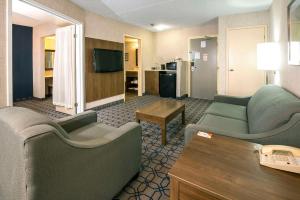 a living room with two couches and a tv at Quality Suites in Whitby