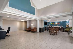 un grand hall avec un coin d'attente, des tables et des chaises dans l'établissement Quality Inn near Seymour Johnson AFB, à Goldsboro