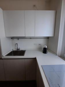 a white kitchen with a sink and white cabinets at Locazione Turistica La Rosa - Navigatori in Verona