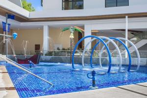 a swimming pool with blue water fountains at Best Western Plus The Ivywall Resort-Panglao in Panglao Island