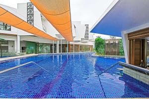 Best Western Plus The Ivywall Resort-Panglao في بنغلاو: مسبح كبير وبلاط ازرق في مبنى