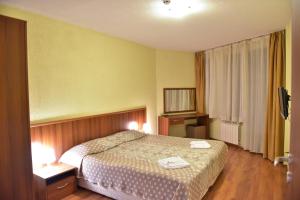 1 dormitorio con 1 cama con 2 toallas en Apart Hotel Comfort, en Bansko