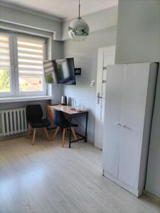 a kitchen with a desk and a white refrigerator at Restauracja Pod Jabłonią in Łącko