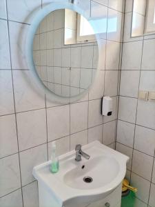 a white bathroom with a sink and a mirror at Restauracja Pod Jabłonią in Łącko