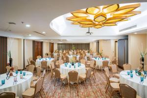a banquet hall with tables and chairs and a large chandelier at Best Western Plus The Ivywall Resort-Panglao in Panglao +143 photos