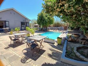 un patio con mesa y sillas junto a una piscina en Ons Stee Bed and Breakfast en Wellington