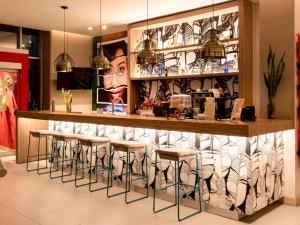 a bar in a restaurant with stools in front of it at ibis Apartado in Apartadó