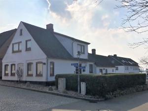a white house with a street sign in front of it at Ferienhaus Friedas Fischerhuus in Maasholm