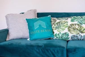 ein blaues Sofa mit einem Kissen, auf dem „Life Stars“ steht in der Unterkunft 3 Bedroom House Ashford, Kent - Free Parking - Free WiFi - Big Monthly Discounts - Sleeps 5 - Elite Stays UK in Ashford + 17 Fotos
