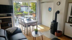 sala de estar con mesa y estufa de leña en Ferienhaus Klönstieg, en Maasholm