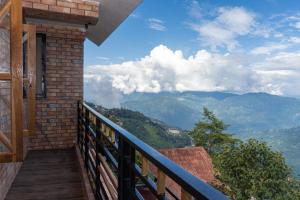 a balcony with a view of the mountains at Bastola Basthan Homestay in Darjeeling