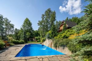 een zwembad in de tuin van een huis bij Kotelnica Resort in Międzybrodzie Bialskie