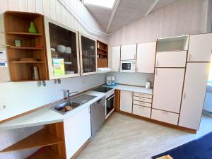 a kitchen with white cabinets and a sink at Ferienhaus Nordlicht in Brodersby