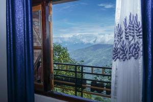 uma janela com vista para a montanha em Bastola Basthan Homestay em Darjeeling