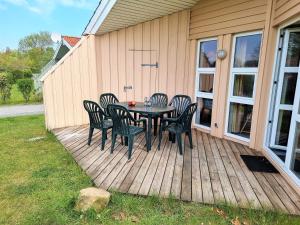 a table and chairs on a wooden deck at Ferienhaus Strandblick 13 in Brodersby