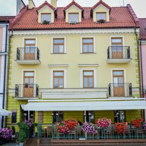 un edificio amarillo con macetas en los balcones en Apartamenty Optimal, en Płock