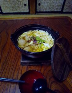 T&T Fujiyama Guest House في فوجيوشيدا: وعاء من الطعام جالس على طاولة