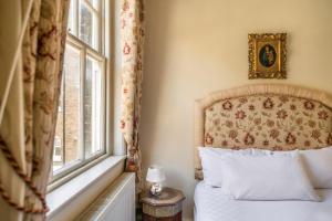 1 dormitorio con cama y ventana en The Grand "Old Boy" - Marylebone - by Frankie Says en Londres