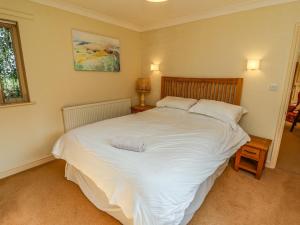 una camera da letto con un grande letto con lenzuola e cuscini bianchi di Hill Top Cottage a Welbourn