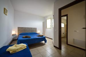 a bedroom with two beds with blue sheets and a mirror at Bivani a 100 m dal mare in Castellammare del Golfo