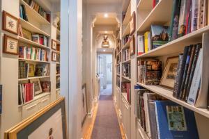 un couloir avec des étagères remplies de livres dans l'établissement The Grand "Old Boy" - Marylebone - by Frankie Says, à Londres