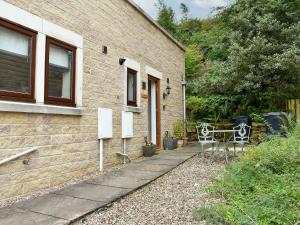 a house with a table and chairs outside of it at Quarry Cottage in Highpeak Junction
